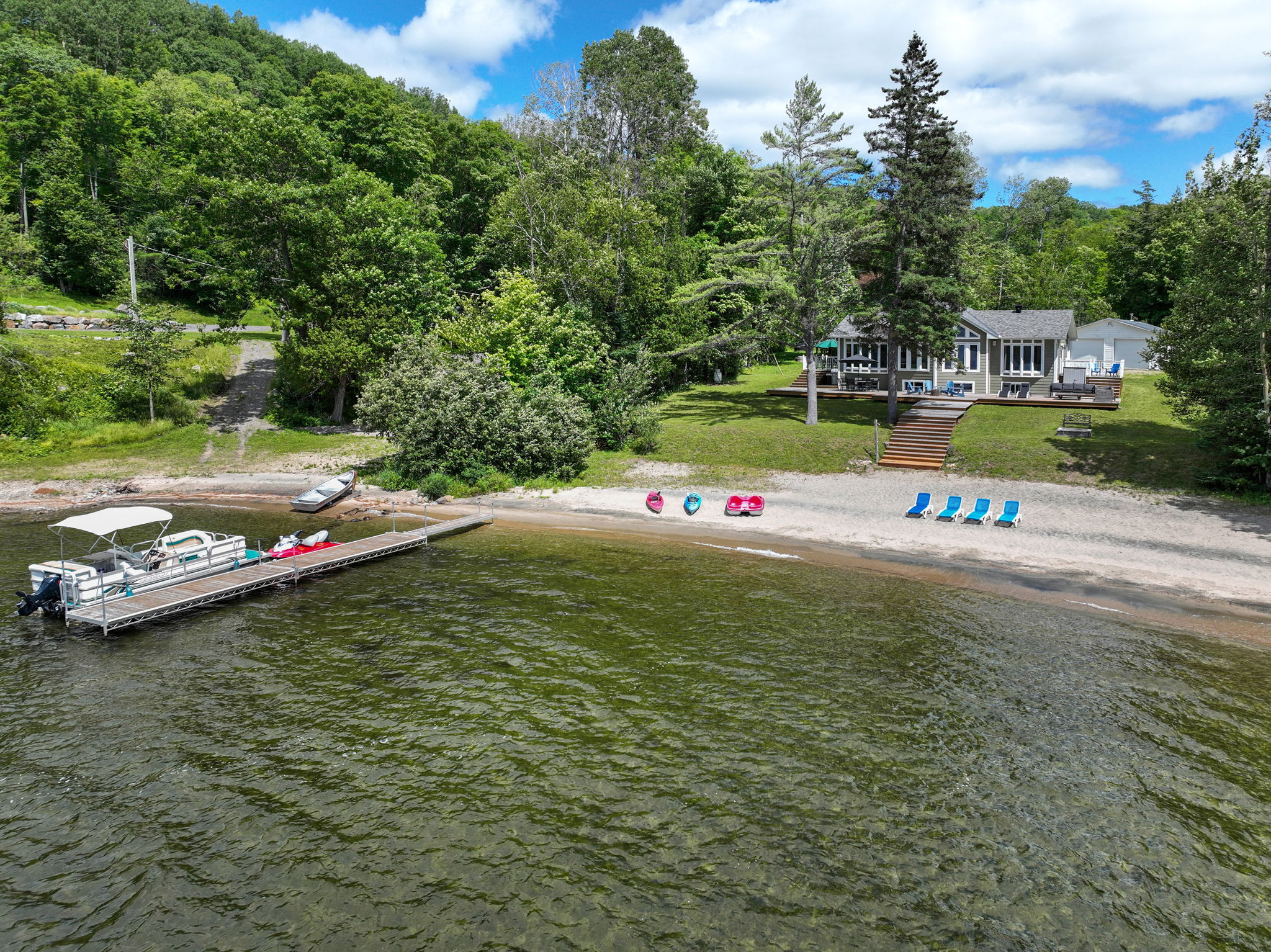 Plage de sable privée avec kayaks, pédalo et quai au chalet de luxe au Québec
